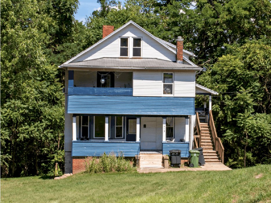 House with blue covered porch and large lawn