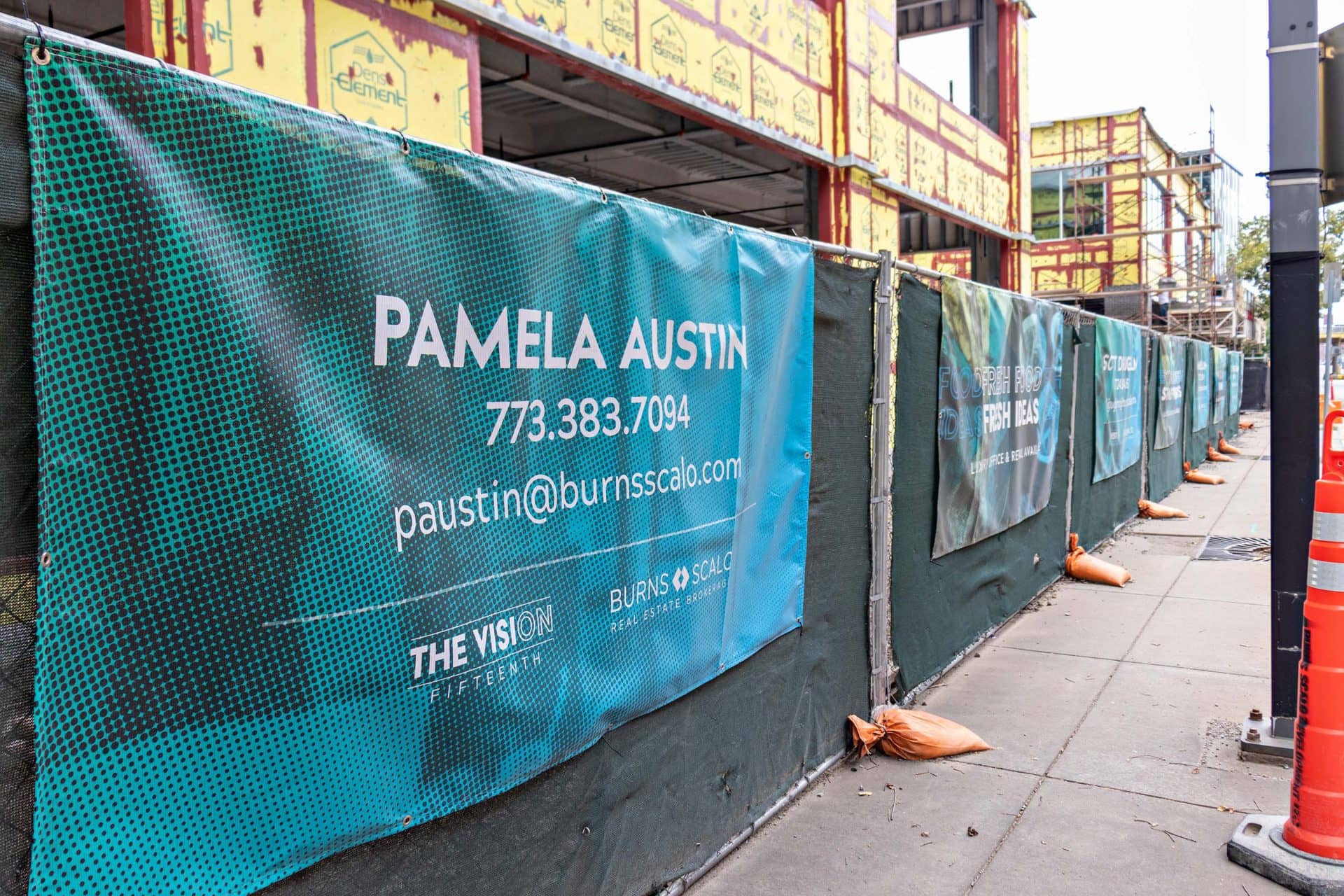 banner that reads pamela austin on fence in front of building under construction